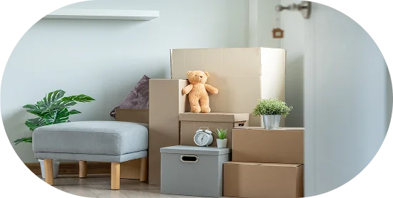 Yeni bir evde mobilyalar ve dekoratif eşyalarla birlikte üst üste konmuş taşınma kutuları, düzenli paketlemeyi gösteriyor.
